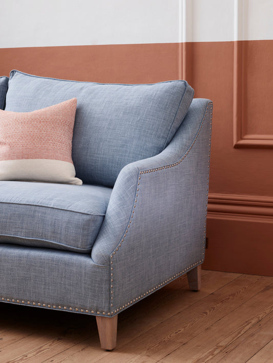 upholstered blue sofa with burnt Sienna wall