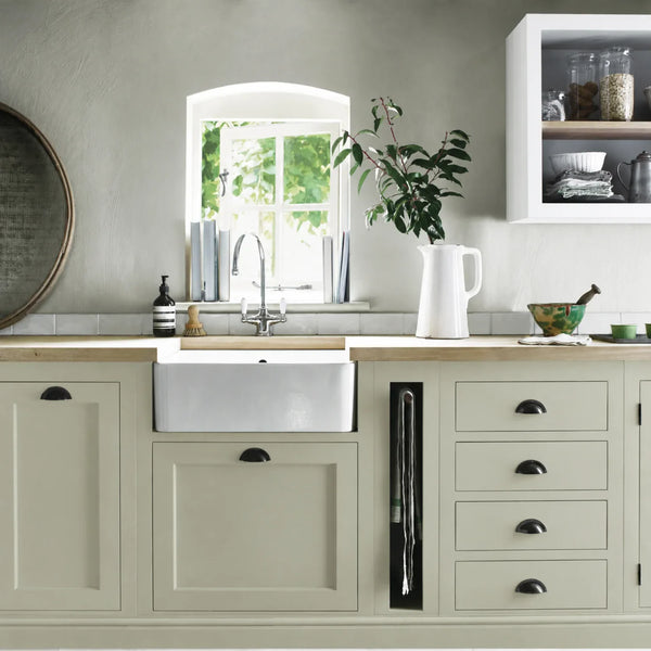Sage green painted Henley kitchen cabinetry with oak worktops and a white farmhouse sink.