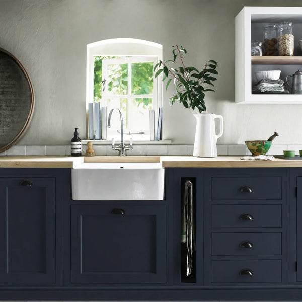 Navy blue painted Henley kitchen cabinetry with oak worktops and a white farmhouse sink.
