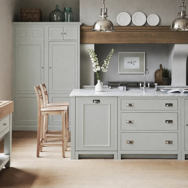 Chichester kitchen with cabinetry painted in Powder Blue, featuring a central island and oak bar stools.