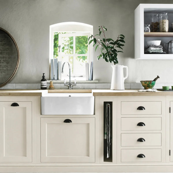 Shell cream painted Henley kitchen cabinetry with oak worktops and a white farmhouse sink.