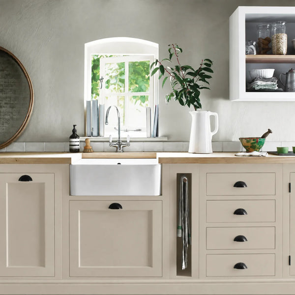 Driftwood beige painted Henley kitchen cabinetry with oak worktops and a white farmhouse sink.