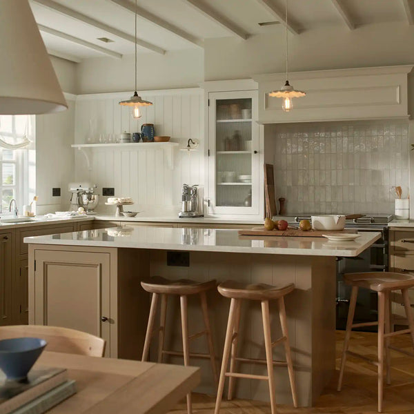 Chichester kitchen in lead light brown painted cabinetry, marble-topped island, solid oak bar stools and pendant lighting.