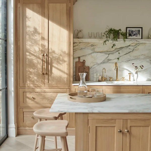Henley oak kitchen with marble worktops, tall cabinetry and a marble-topped island.