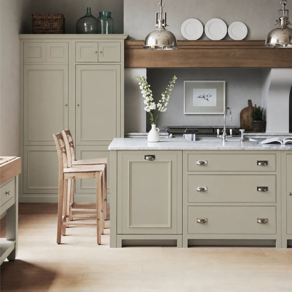 Chichester kitchen with cabinetry painted in French Grey, featuring a central island and oak bar stools.
