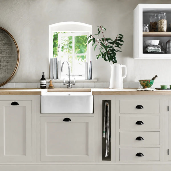 Shingle cream grey painted Henley kitchen cabinetry with oak worktops and a white farmhouse sink.