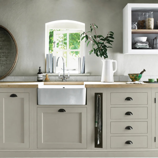 Mist beige cream painted Henley kitchen cabinetry with oak worktops and a white farmhouse sink.