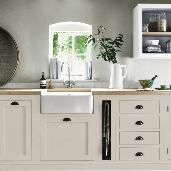 Lily cream painted Henley kitchen cabinetry with oak worktops and a white farmhouse sink.