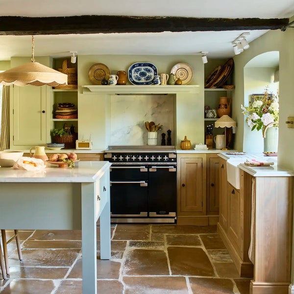 Henley oak country kitchen with green painted details, range cooker and stone flooring.