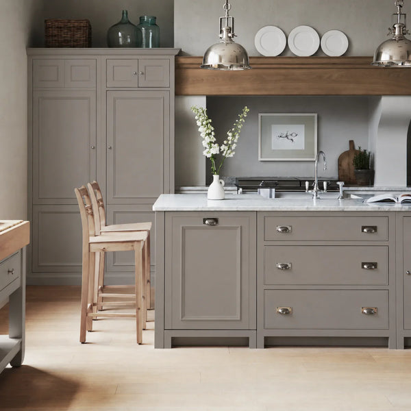 Chichester kitchen with cabinetry painted in Grey Oak, featuring a central island and oak bar stools.