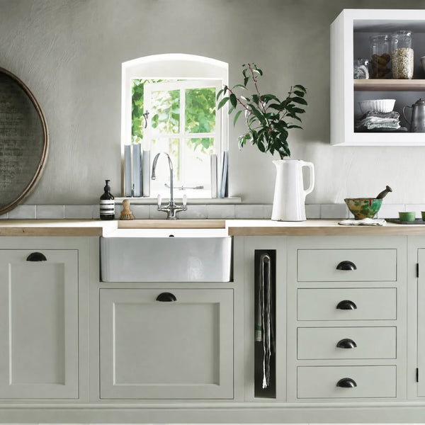 Alpine grey green painted Henley kitchen cabinetry with oak worktops and a white farmhouse sink.