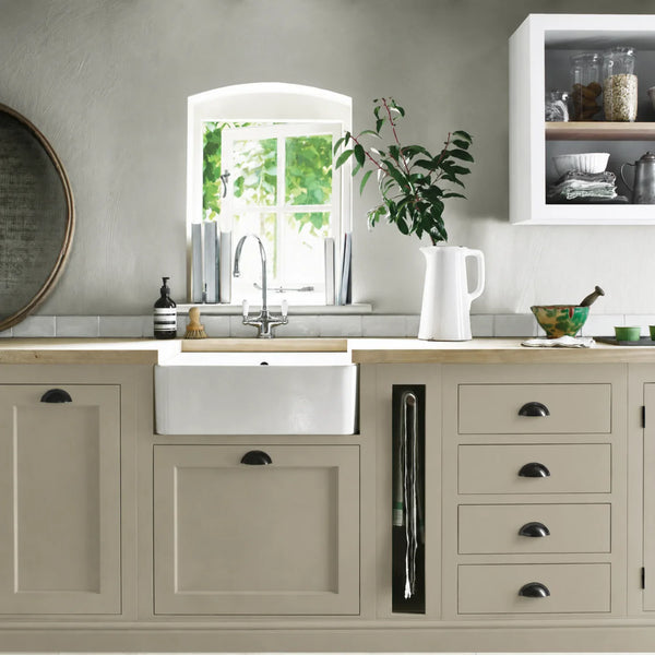 Honed Slate beige grey painted Henley kitchen cabinetry with oak worktops and a white farmhouse sink.