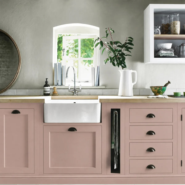 Old Rose pink painted Henley kitchen cabinetry with oak worktops and a white farmhouse sink.