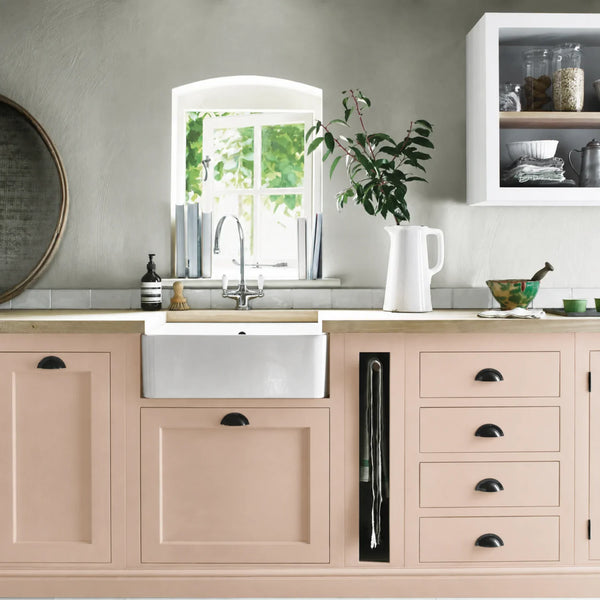 Potters Pink painted Henley kitchen cabinetry with oak worktops and a white farmhouse sink.