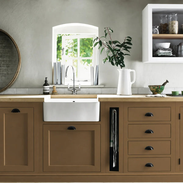 Saddle brown painted Henley kitchen cabinetry with oak worktops and a white farmhouse sink.