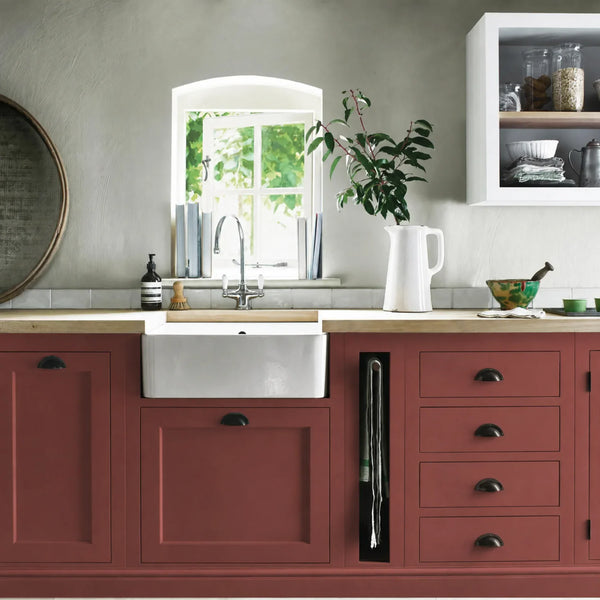 Paprika red painted Henley kitchen cabinetry with oak worktops and a white farmhouse sink.
