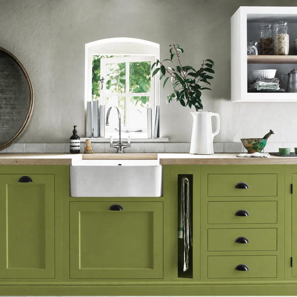 Nettle green painted Henley kitchen cabinetry with oak worktops and a white farmhouse sink.