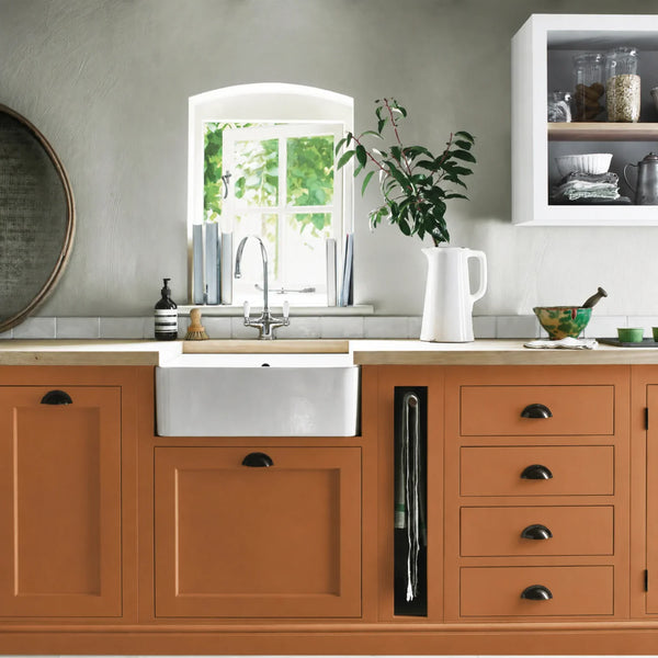 Bracken orange painted Henley kitchen cabinetry with oak worktops and a white farmhouse sink.