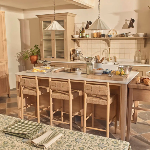 Borough kitchen with freestanding oak island, woven bar stools, marble worktops and fitted painted cabinetry.