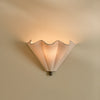 Athena linen scalloped wall light with bronze accents on beige wall, lights on