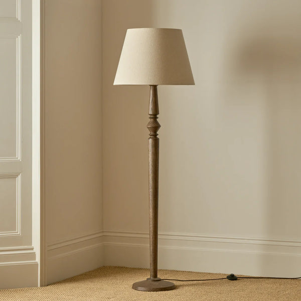 Chalford darkened oak floor lamp with linen shade in a carpeted room with beige walls
