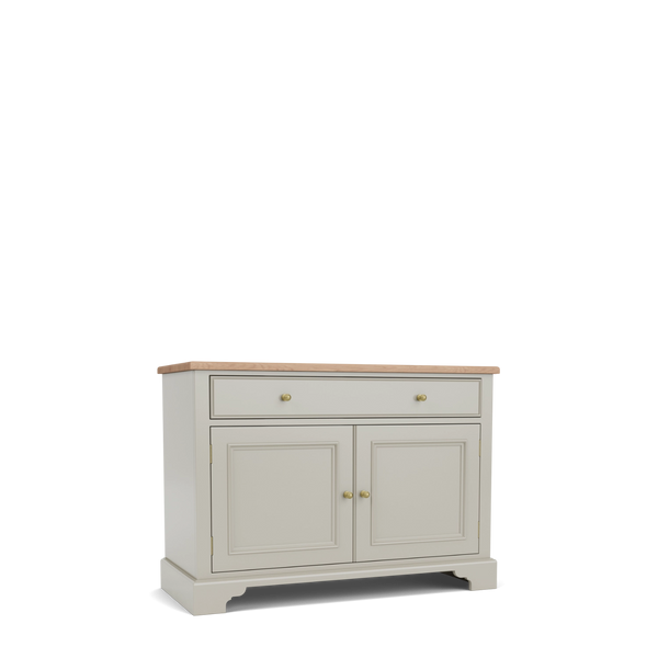 A classic sideboard cabinet with a light beige painted finish, a natural oak wood top, two drawers at the top with brass knobs, and two paneled doors below with matching knobs, shown on a white background.