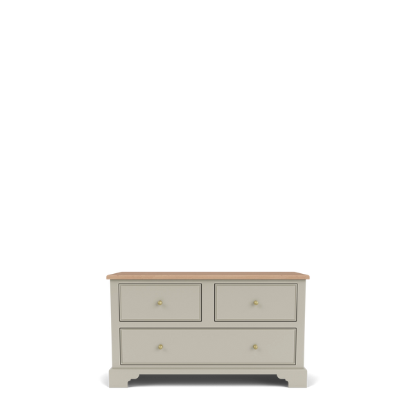 A classic four-drawer chest of drawers in a warm grayish-beige finish with a natural light wood top and small brass knobs, shown on a clean white background.
