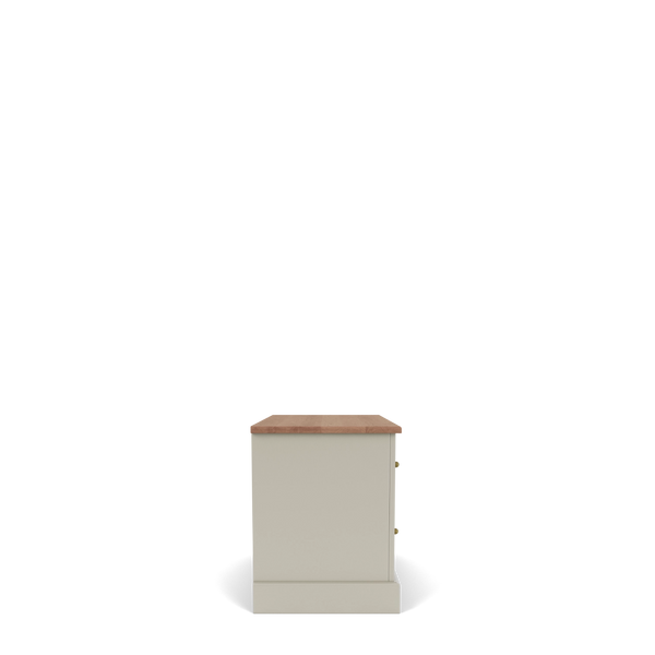 A side view of a small cabinet or nightstand with a warm beige-painted body, a natural wood top, and two small brass knobs, shown on a white background.