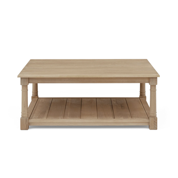 A light natural wood coffee table with a two-tier design, featuring a rectangular top and a slatted lower shelf, supported by turned legs, shown against a plain white background.