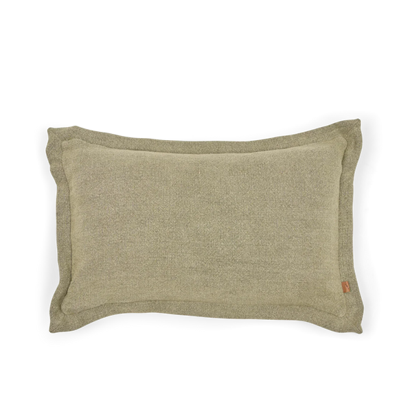 A rectangular lumbar pillow in a textured sage green fabric, featuring a small brown leather brand tag on the lower right corner, set against a plain white background.