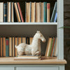 Hickstead Horse ornament displayed on stacked books in a painted bookshelf