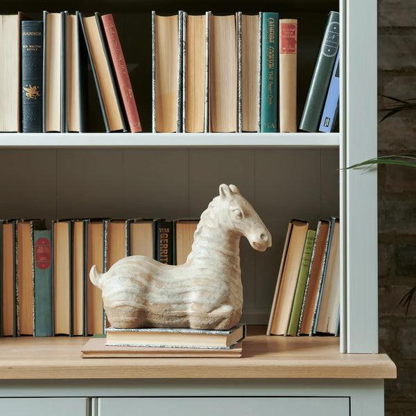 Hickstead Horse ornament displayed on stacked books in a painted bookshelf
