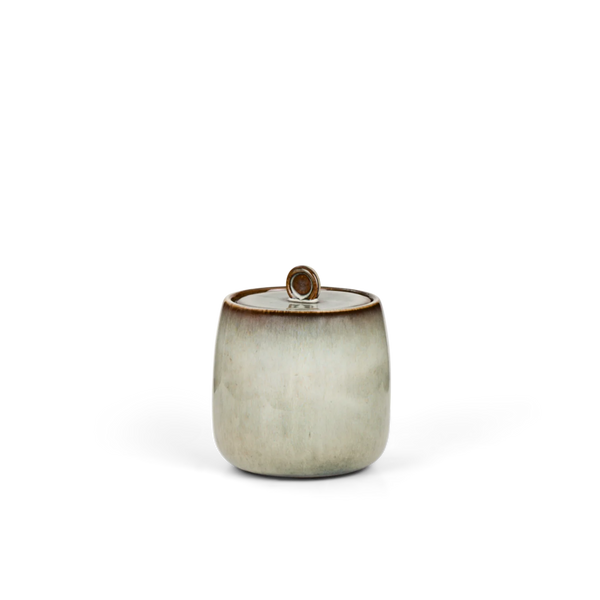 Cream ceramic sugar pot with brown glazed rim on white background.