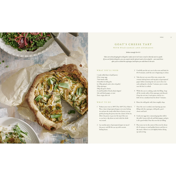 A printed recipe card for Goat's Cheese Tart with Wild Garlic and Herbs, shown beside a plated tart and salad on a white tabletop. The left side features a large photo of the baked tart, while the right side contains ingredients, instructions, and a small ingredient list in a clean serif layout.