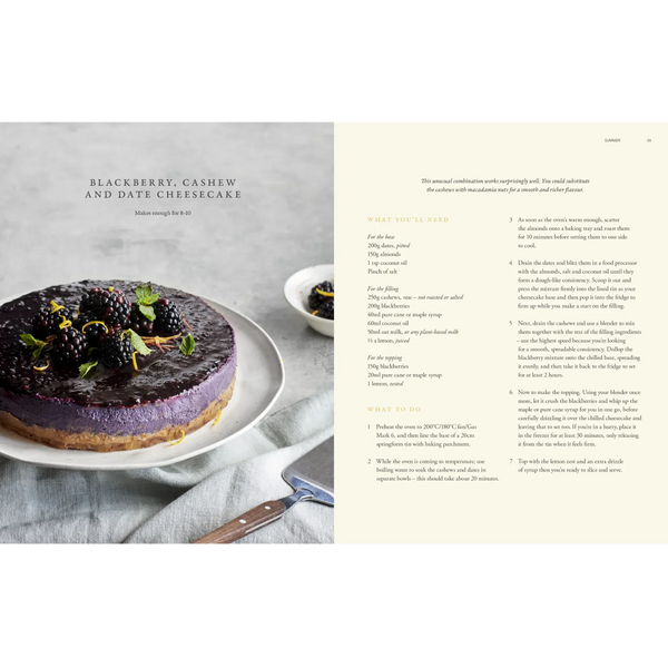 An open cookbook or recipe book spread showing a blackberry, cashew, and date cheesecake on the left page with a photo of the dessert, and step-by-step preparation instructions on the right page.