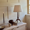 Thornbury darkened oak table lamp on oak sideboard, beside decorative vases and tapered candle in brass holder