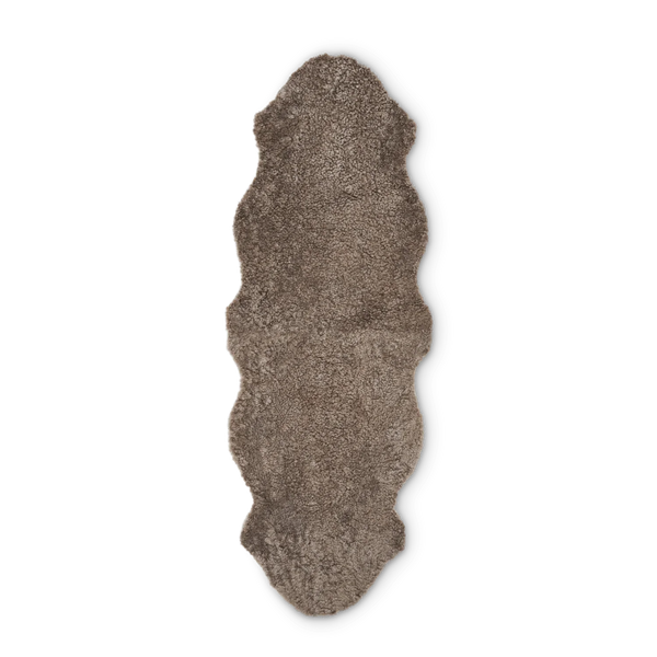 A shaggy, textured area rug with an irregular, natural hide silhouette in a warm taupe-brown color, shown flat against a solid white background.