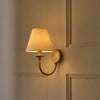 Wilton single wall light with linen shade and brass fitting, light on
