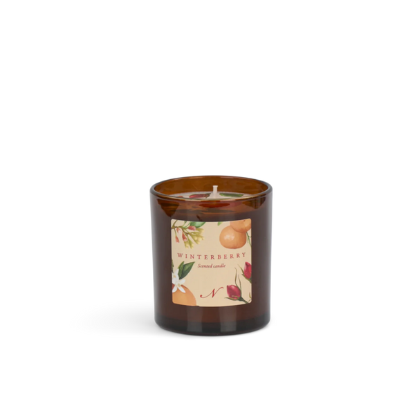 An amber glass jar candle with a cream-colored wick and label on a white background