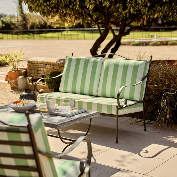 Outdoor patio setting with green and white striped furniture and table.