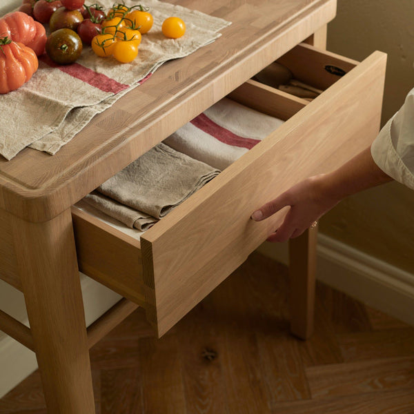 A close up of the Neptune Borough Butchers Block showing the drawer slightly open and filled with dish cloths
