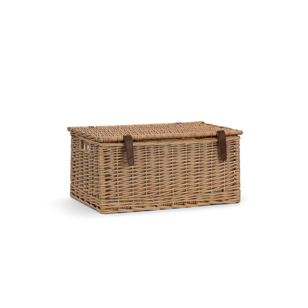 A rectangular woven wicker storage basket with a hinged lid and two dark brown leather strap closures, shown on a plain white background.