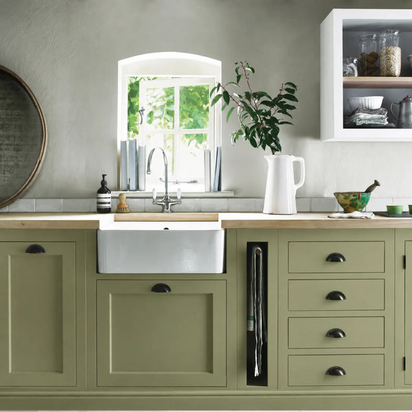 Olive green painted Henley kitchen cabinetry with oak worktops and a white farmhouse sink.