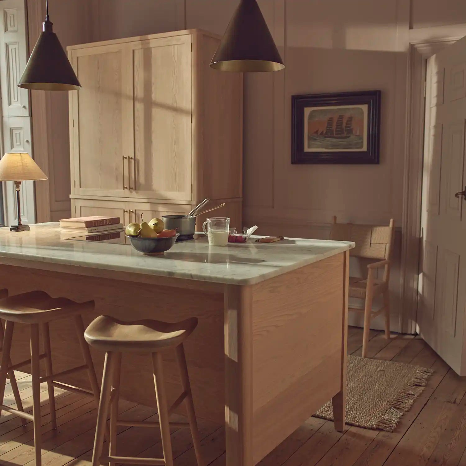 Freestanding Borough kitchen with natural oak island, tall larder cabinet and marble worktops.