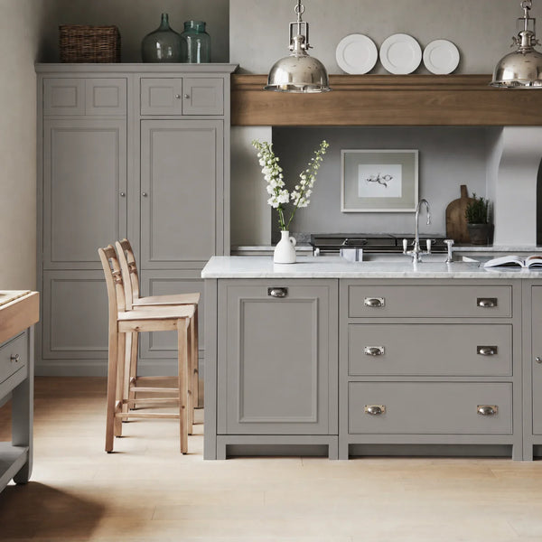 Chichester kitchen with cabinetry painted in Cobble grey, featuring a central island and oak bar stools.