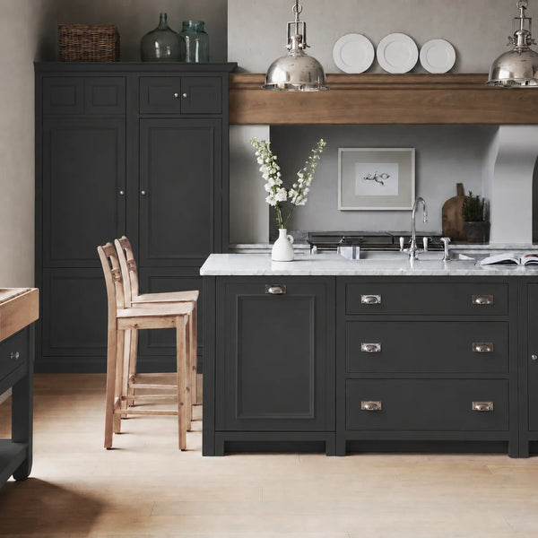 Chichester kitchen with cabinetry painted in Charcoal dark grey, featuring a central island and oak bar stools.