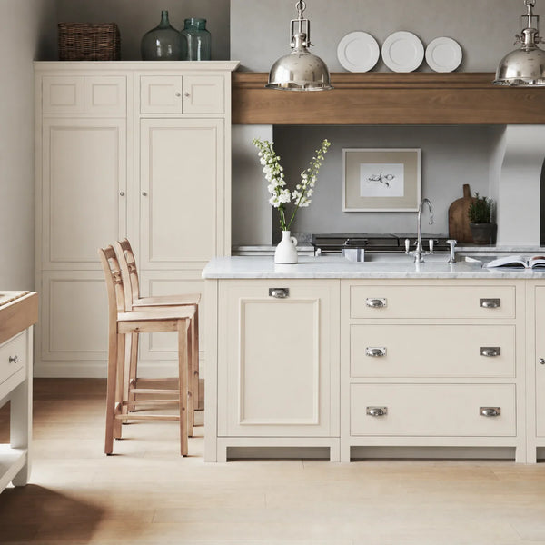 Chichester kitchen with cabinetry painted in Salt white, featuring a central island and oak bar stools.