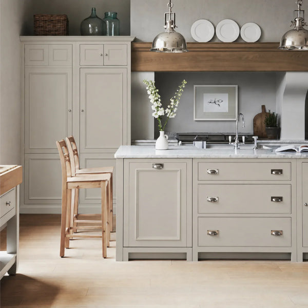 Chichester kitchen with cabinetry painted in Shingle grey cream, featuring a central island and oak bar stools.