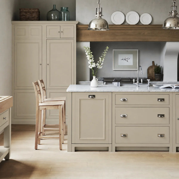 Chichester kitchen with cabinetry painted in Dove Grey, featuring a central island and oak bar stools.