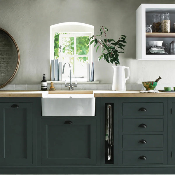 Constable Green painted Henley kitchen cabinetry with oak worktops and a white farmhouse sink.